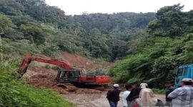 Sebuah alat berat jenis ekskavator saat membersihkan material longsor di ruas jalan Jembatan Merah - Muarasoma.
