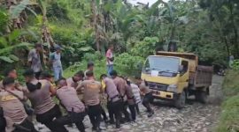 Sejumlah personel Polda Sumut berjibaku menarik angkutan yang membawa logistik Pilkada 2024 saat melewati jalur pengunungan di Kabupaten Nias, Selasa (26/11/2024). (Foto: Diva Suwanda)
