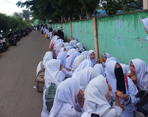Puluhan siswa duduk di jalan setelah sekolah mereka, Madrasah Tsanawiyah Al-Washliyah di Desa Petumbukan, Kecamatan Galang, Kabupaten Deliserdang, Sumatera Utara (Sumut), disegel Pemkab Deliserdang. (Foto: Diva Suwanda)