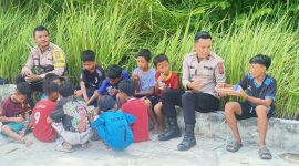 Wakapolsek Tanjung Beringin, Ipda Brimen Sihotang (dua kanan) didampingi Bripka Edward Manalu saat bercengkrama bersama anak-anak di Kecamatan Tanjung Beringin (Foto: Diva Suwanda)