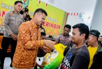 TNI-Polri dan Pemkab Sergai melakukan penyaluran bantuan sosial di Aula Kantor Camat Tanjung Beringin dan diserahkan langsung oleh Wakil Bupati Sergai, Dr H Adlin Umar Yusri Tambunan, ST, MSP didampingi Wakapolsek Tanjung Beringin Ipda Brimen. (Foto: Diva Suwanda)